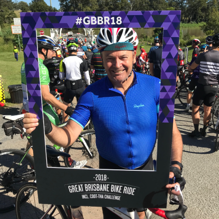 A man clicking picture with a Corflute Selfie Frame during a bike ride event.